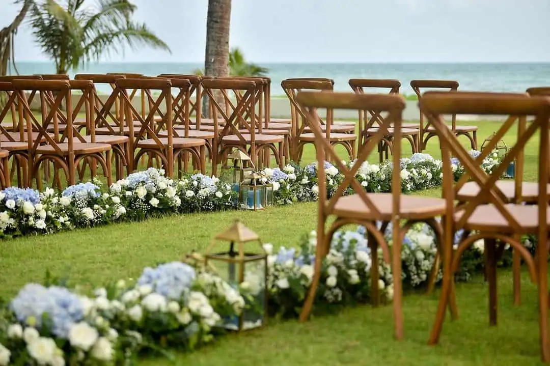 Aisle and ceremony florals at a Phuket wedding — pedestals and aisle markers in the same palette as the reception