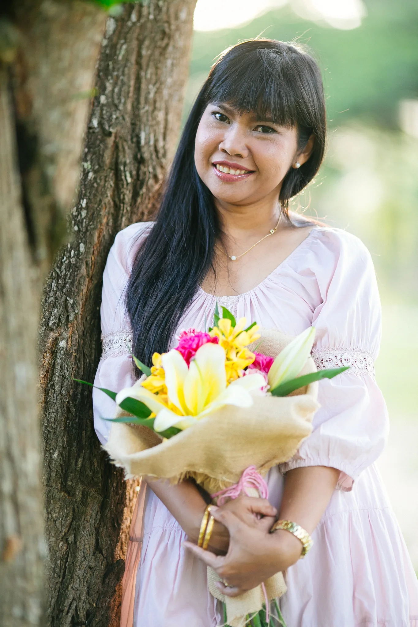 Supparin, lead floral designer at Wedding Flowers Phuket, holding a finished bridal bouquet