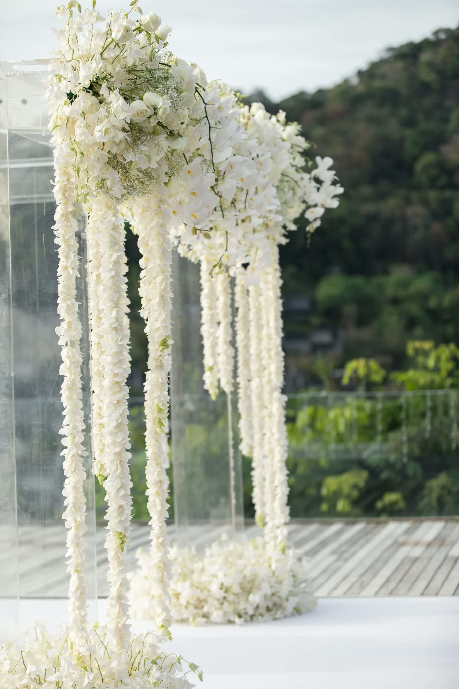 Cascading white orchid ceremony arch at a Villa Santisuk wedding in Phuket, designed by Wedding Flowers Phuket