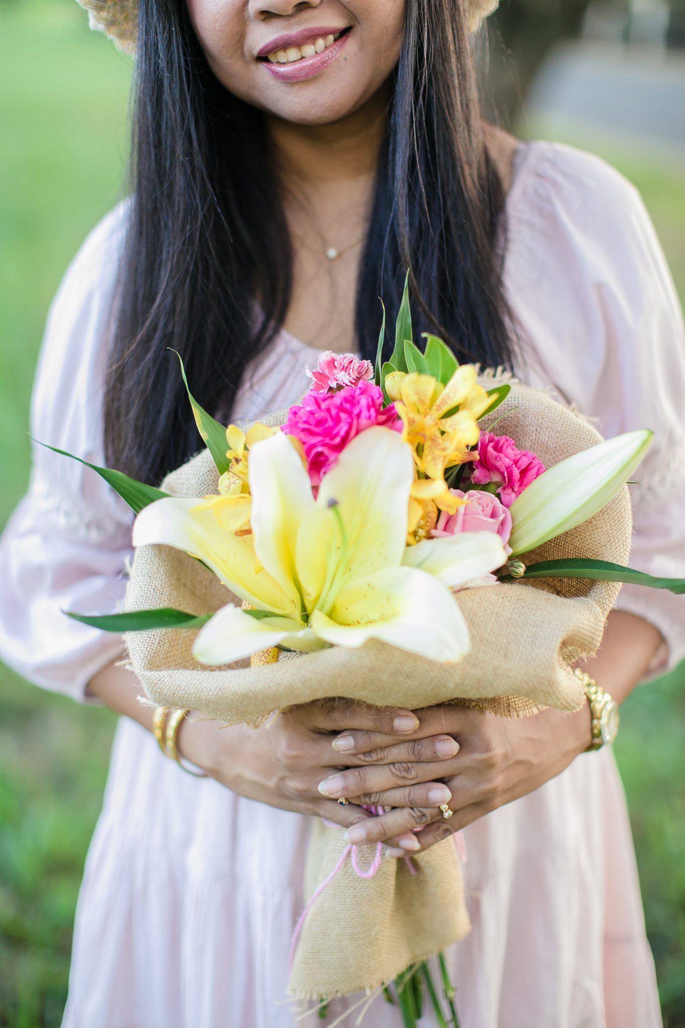 Supparin, lead floral designer at Wedding Flowers Phuket, photographed at work with a large hand-tied bouquet
